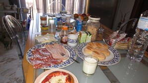 A breakfast table with plates of food, including a pizza, bread, and a glass of milk. - Selene Policlinico di Catania (Gravina di Catania)