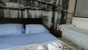 A hotel room with a bed, a sofa, and a cityscape mural on the wall. - Selene Policlinico di Catania (Gravina di Catania)