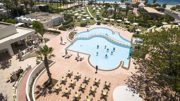 A resort with a large pool, sun loungers, and a view of the ocean. - CALIMERA Delfino Beach Resort & Spa - All inclusive (Hammamet)