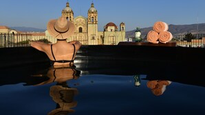 A person in a pool with a reflection of a building and towels. - Hotel Los Amantes (Oaxaca)