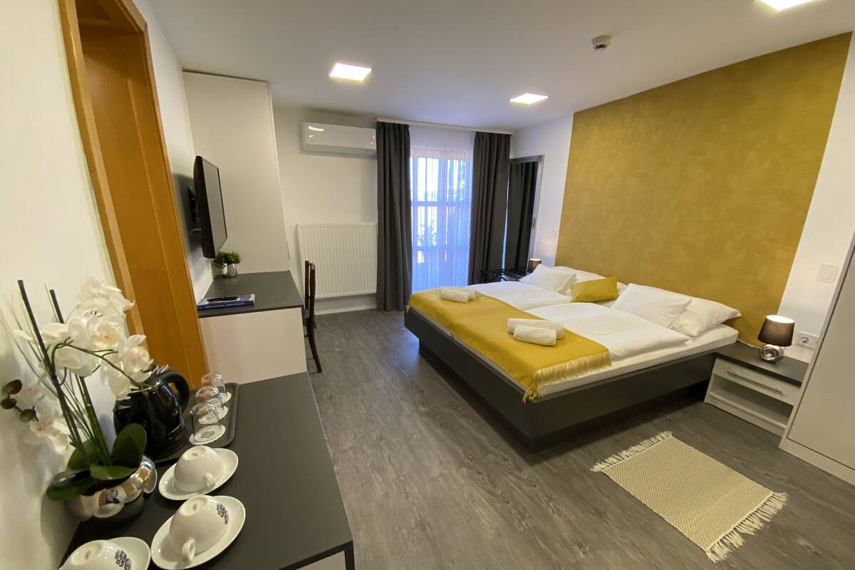 Una habitación de hotel con una cama, una mesita de noche y un escritorio con una silla.