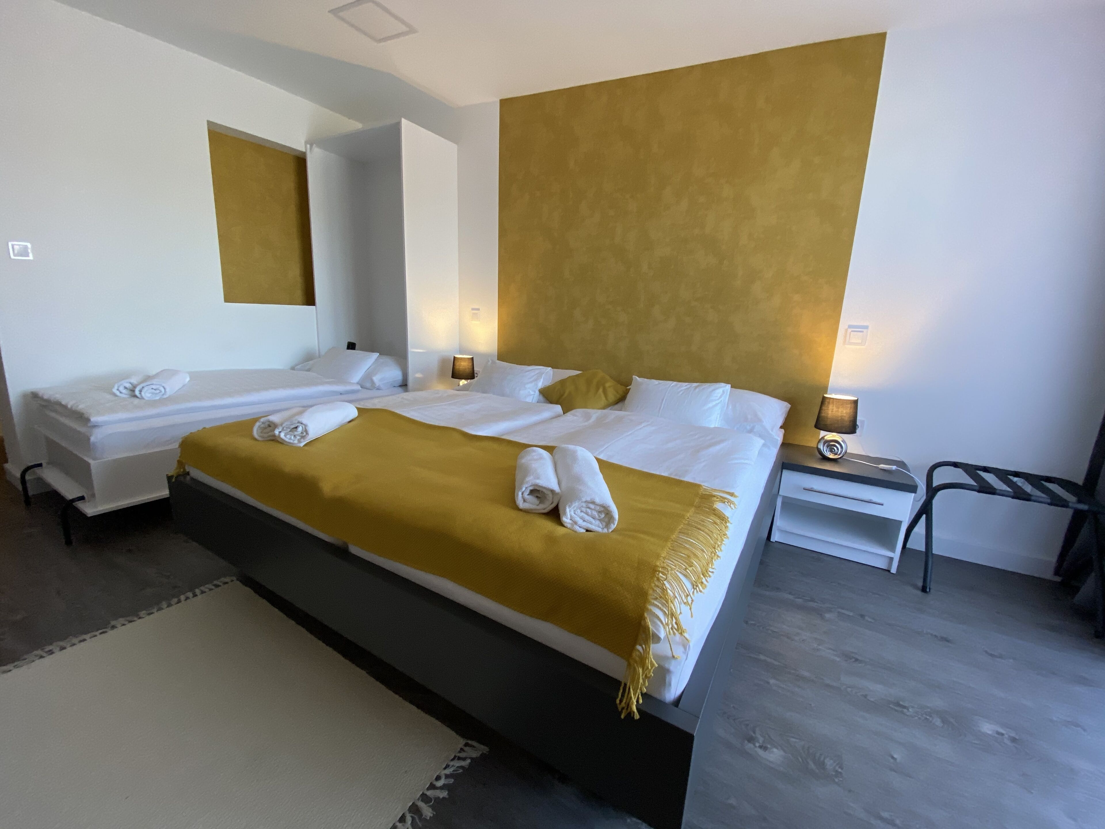 A hotel room with two beds, a large mirror, and a modern design.