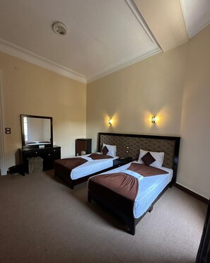 A hotel room with two beds, a dresser, a mirror, and wall sconces. - Paradise Boutique Hotel (Cairo)