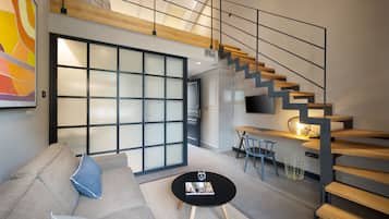 Habitación Deluxe, 1 cama King size y sofá cama, mezzanine | Área de sala de estar | Smart TV de 65 pulgadas con canales vía satélite, televisión y Netflix