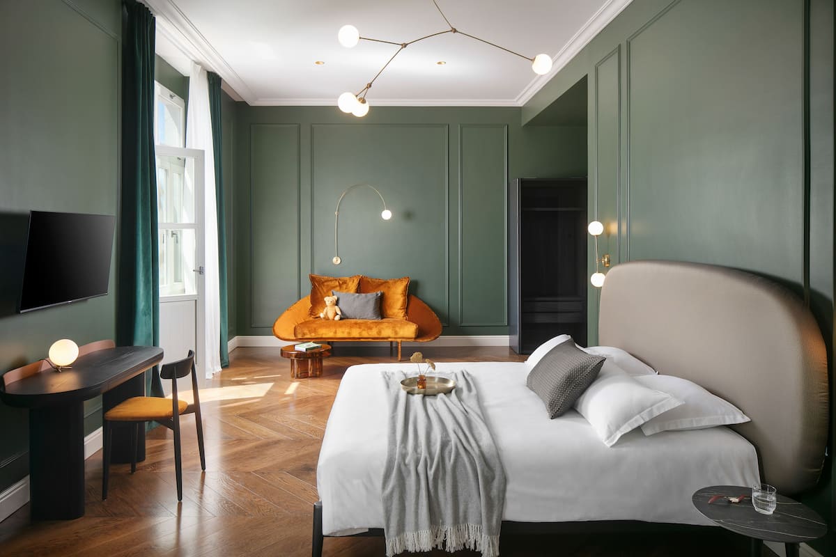 Une chambre d’hôtel moderne avec un grand lit, un bureau et un canapé.