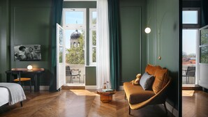 A room with a bed, a sofa, a small table with a lamp, and a view of a building through a window. - Almayer Art & Heritage Adults Only Hotel & Dépendance Rooms (Zadar)