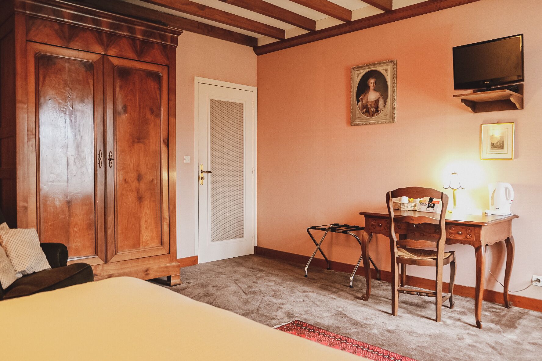 Una habitación con cama, un escritorio y una silla, televisión y armario.