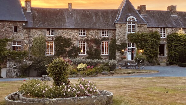 A stone building with multiple windows and a well-maintained garden. - Château de la Roque (Thereval)