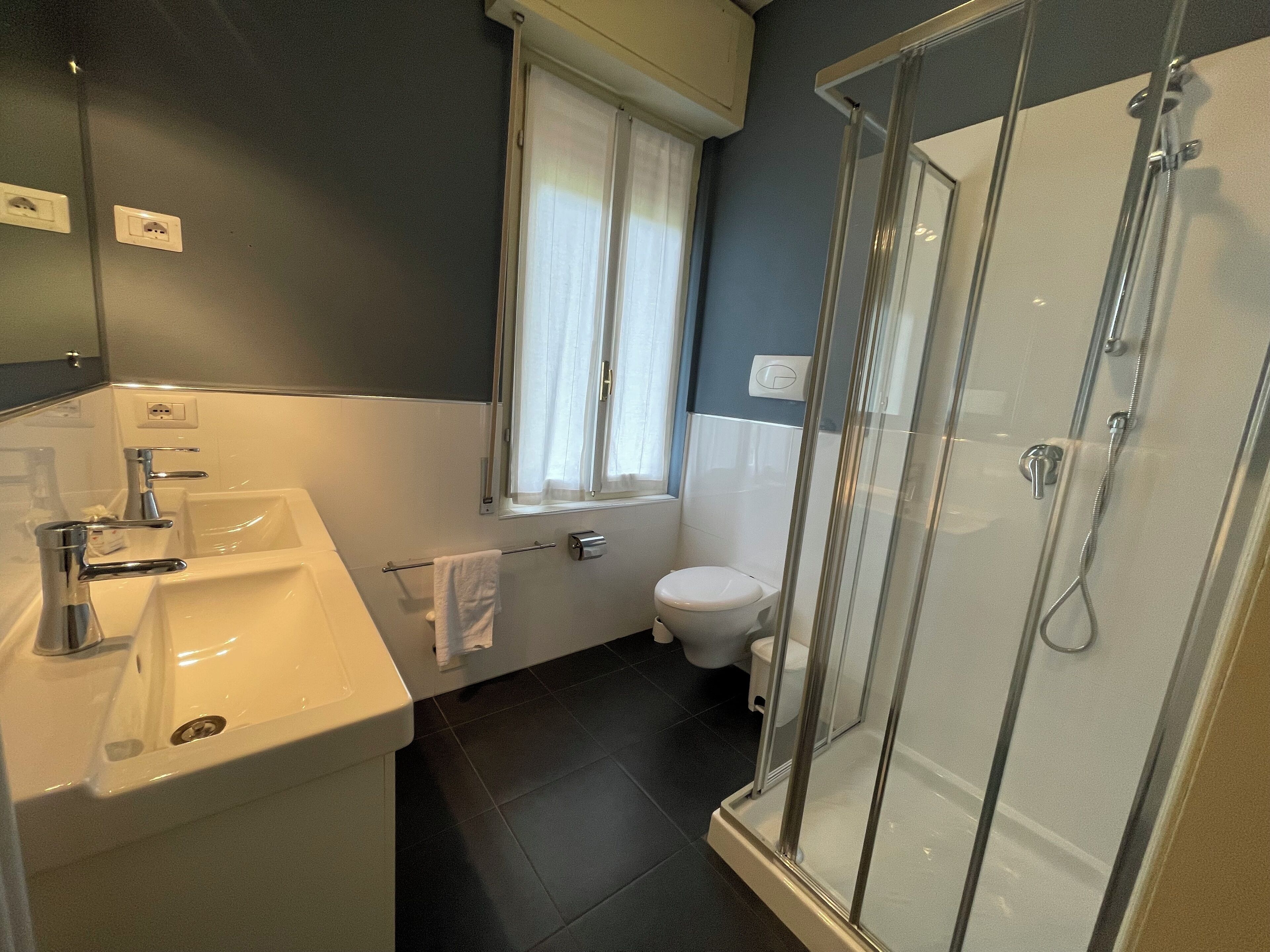 Een badkamer met een wastafel, toilet en douchecabine.
