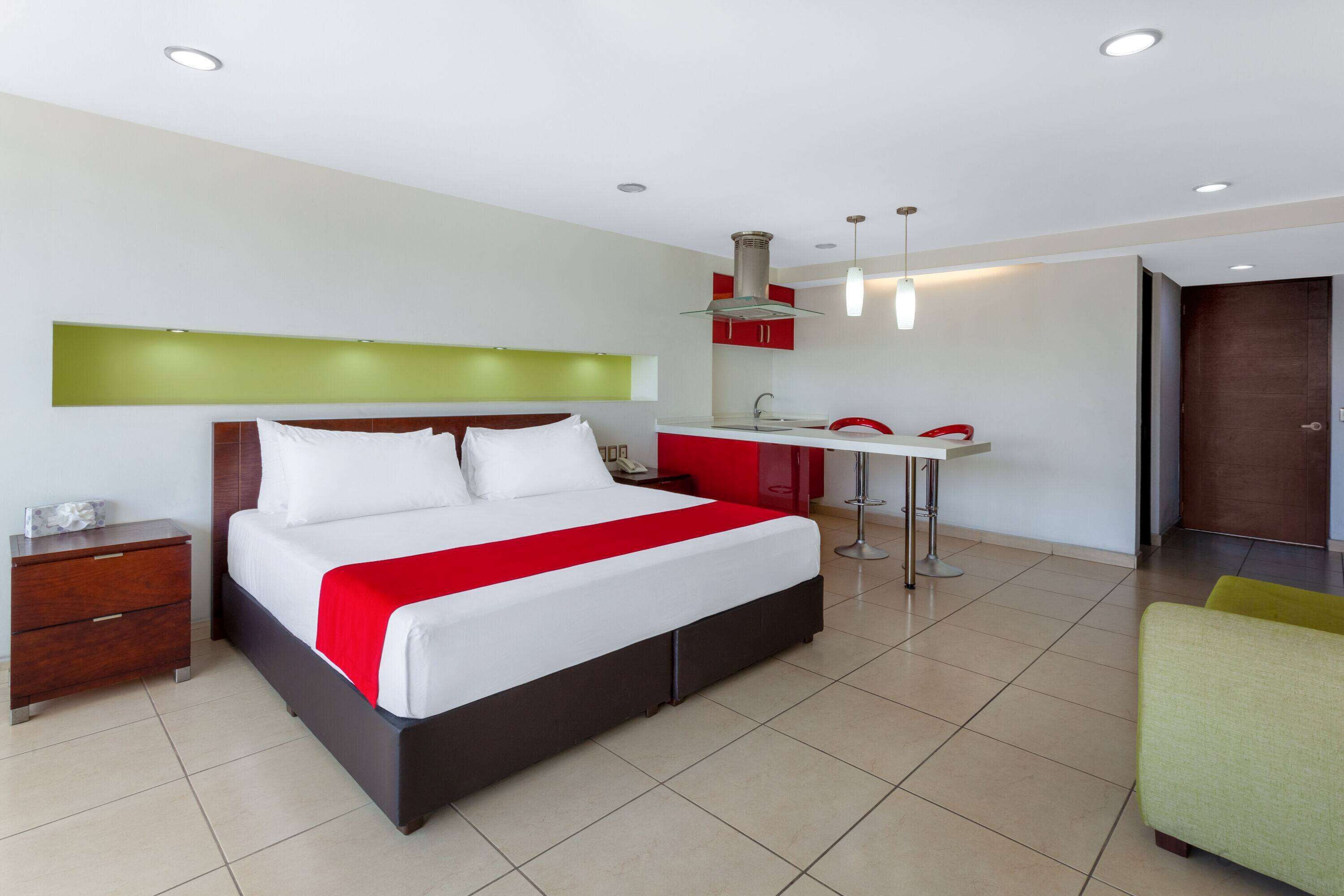 A modern hotel room with a large bed, a desk, and a chair.