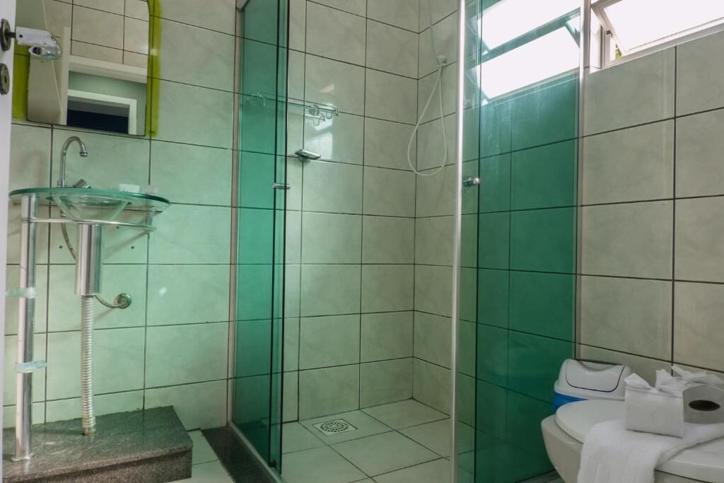 Ein Badezimmer mit Duschkabine, Waschbecken und Toilette.