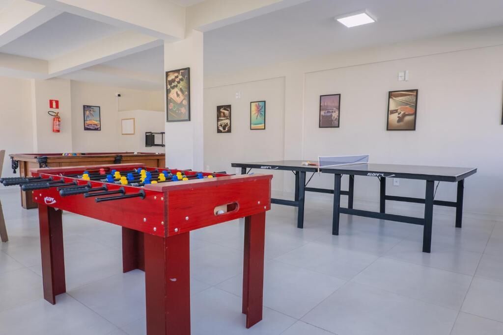 Een kamer met een tafelvoetbaltafel, een pingpongtafel en kunstwerken aan de wanden.