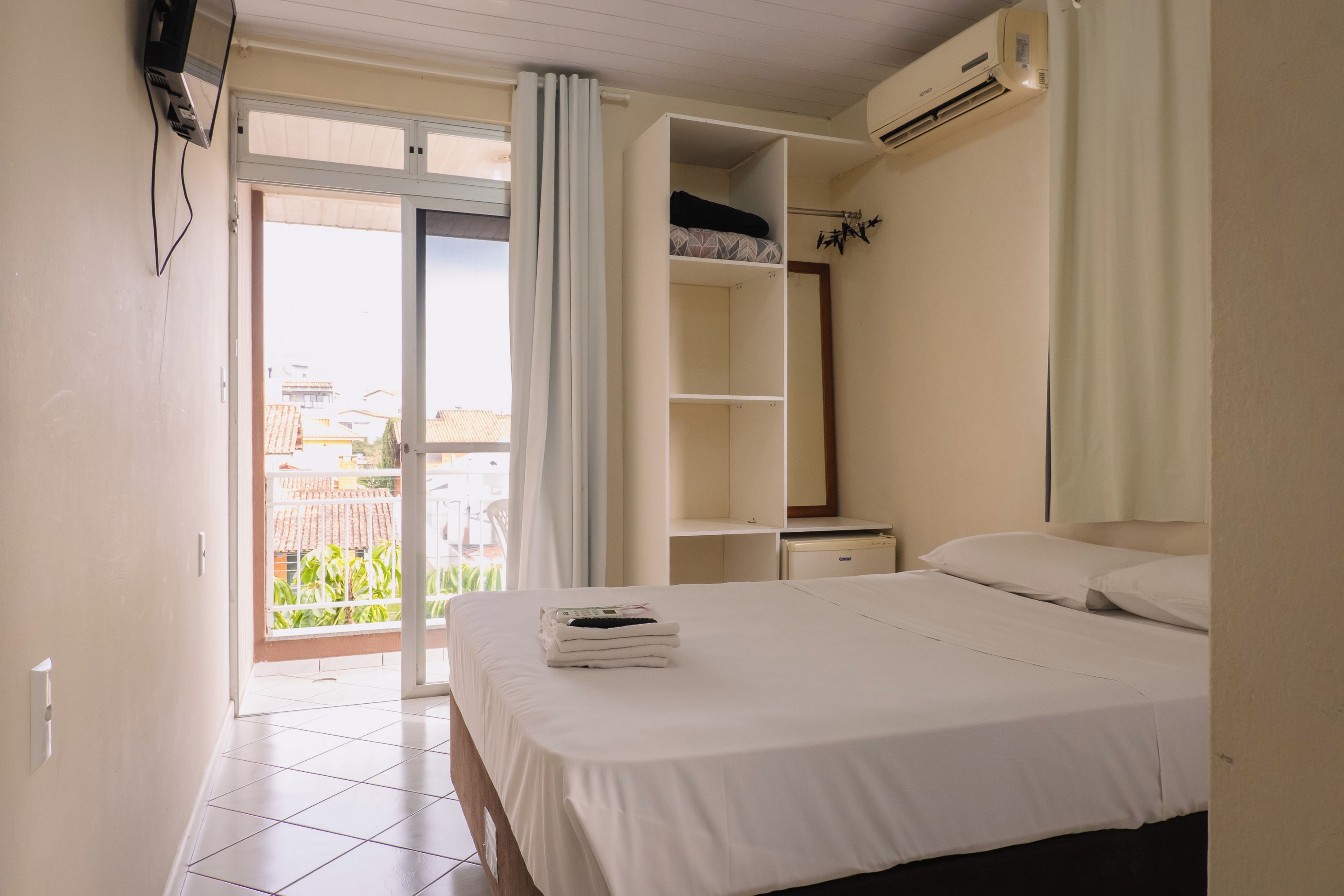 Une chambre d’hôtel avec un lit, une armoire, une salle de bain et une vue sur l’extérieur.