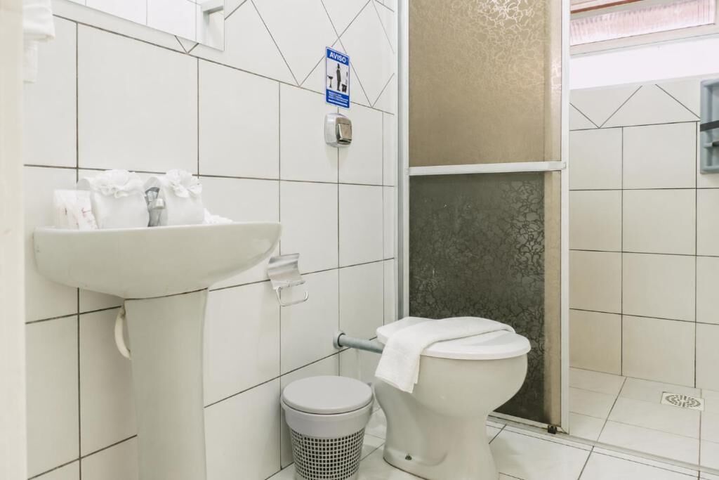 A bathroom with a toilet, sink, and shower.