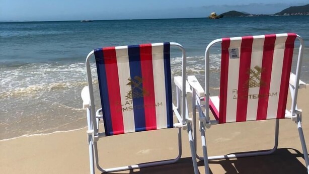 Two beach chairs with striped cushions facing the sea. - HANNA Amsterdam Hotel & Events (Florianópolis)