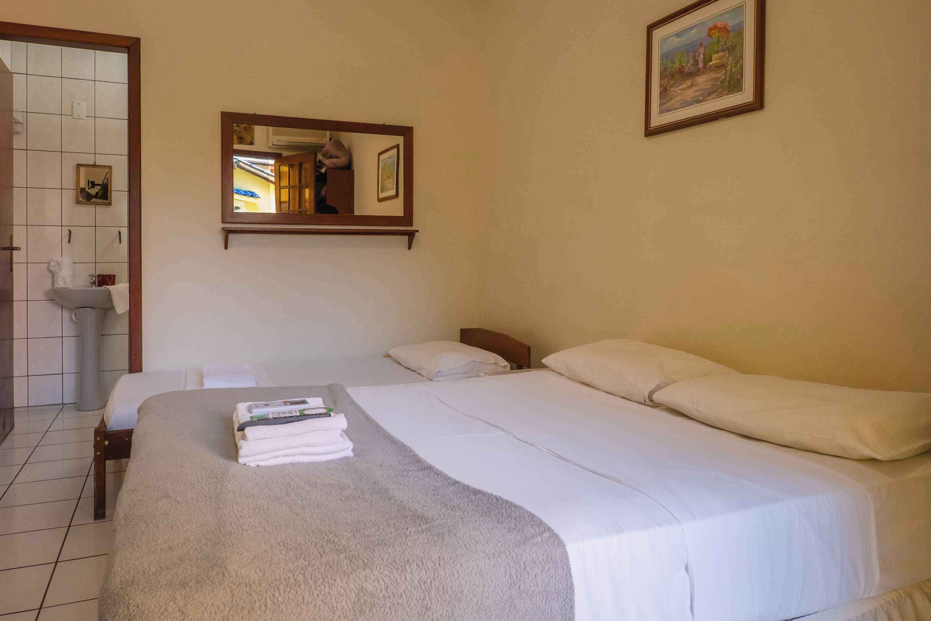 Habitació d'hotel amb un llit, un bany i un quadre a la paret.