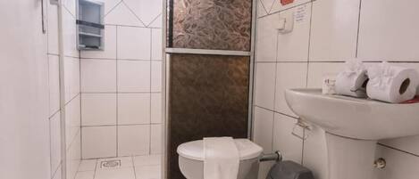 Baño con inodoro, lavamanos y cubo de basura.