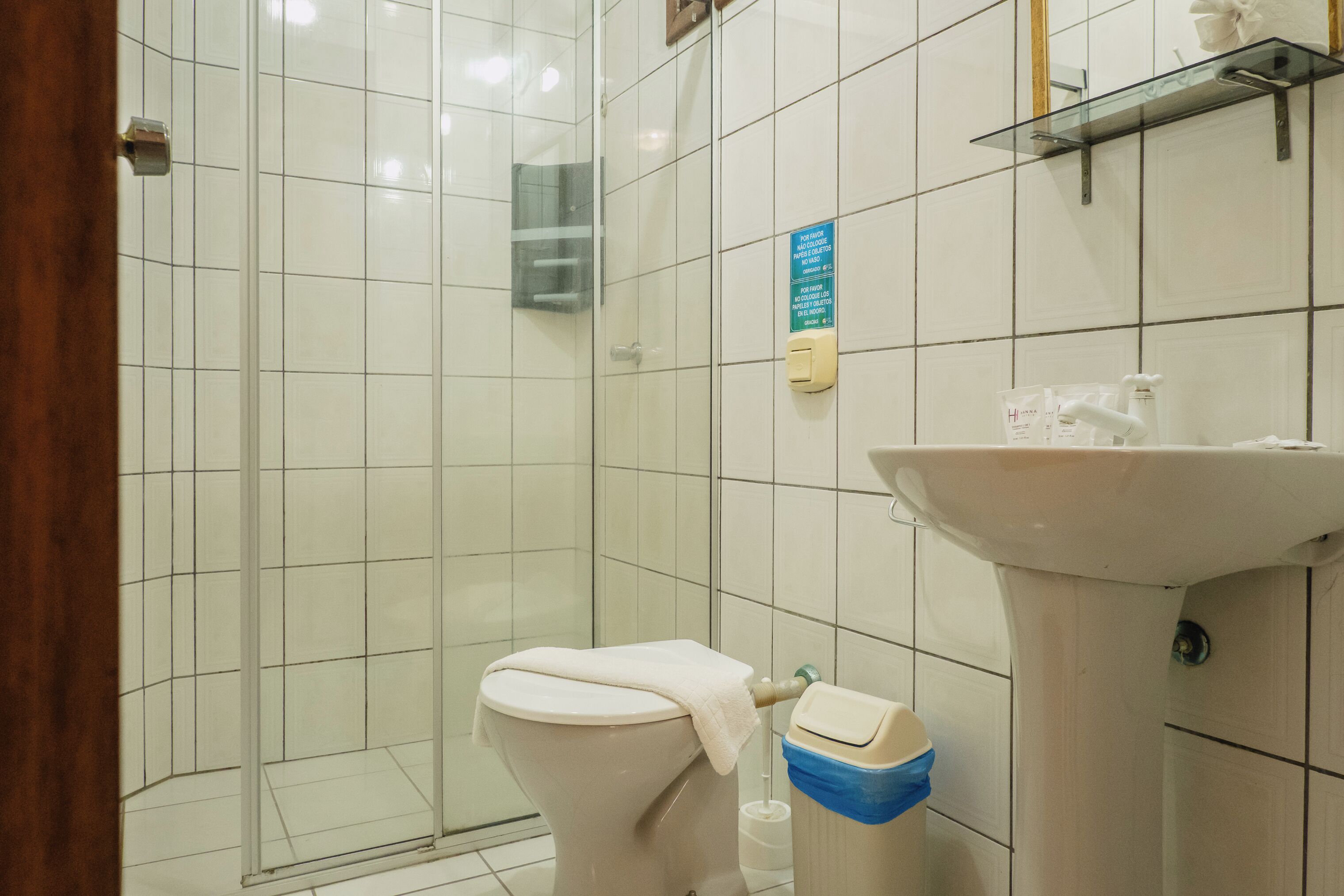 A bathroom with a toilet, a sink, and a glass shower enclosure.