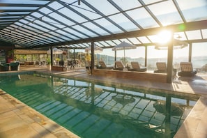 Una piscina techada, sillones reclinables de piscina