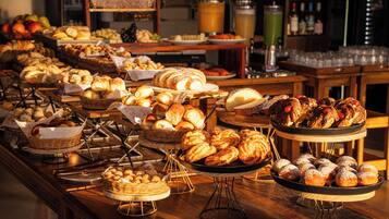 Buffet com diversos pães e doces.