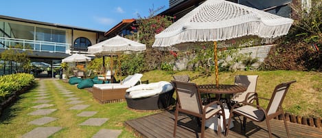 Terraza con mobiliario exterior, sombrillas y zona de piscina.