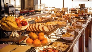 Un buffet proposant une variété d’aliments, notamment des fruits, du pain et des pâtisseries.