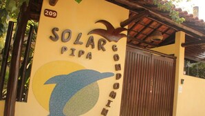 A building entrance with a sign reading "SOLAR COMPOSITORIO" and a dolphin graphic. - Solar De Pipa Duplex Flat (Tibau do Sul)