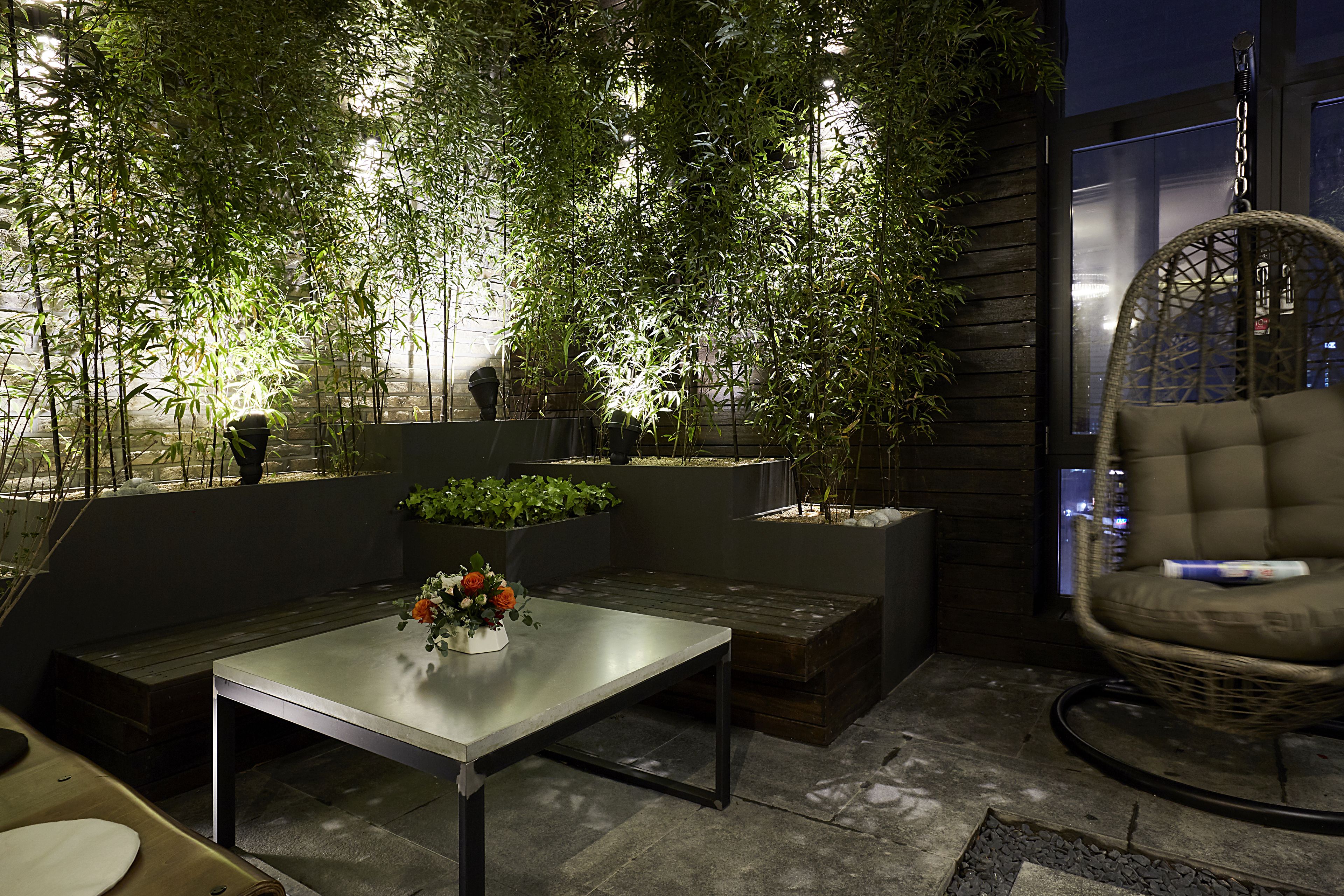 An outdoor seating area with a table, chairs, and planters.