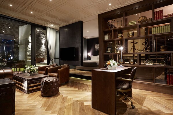 A modern living room with leather furniture, a flat-screen TV, and a bookshelf filled with decorative items. - 9 Brick Hotel (Seoul)