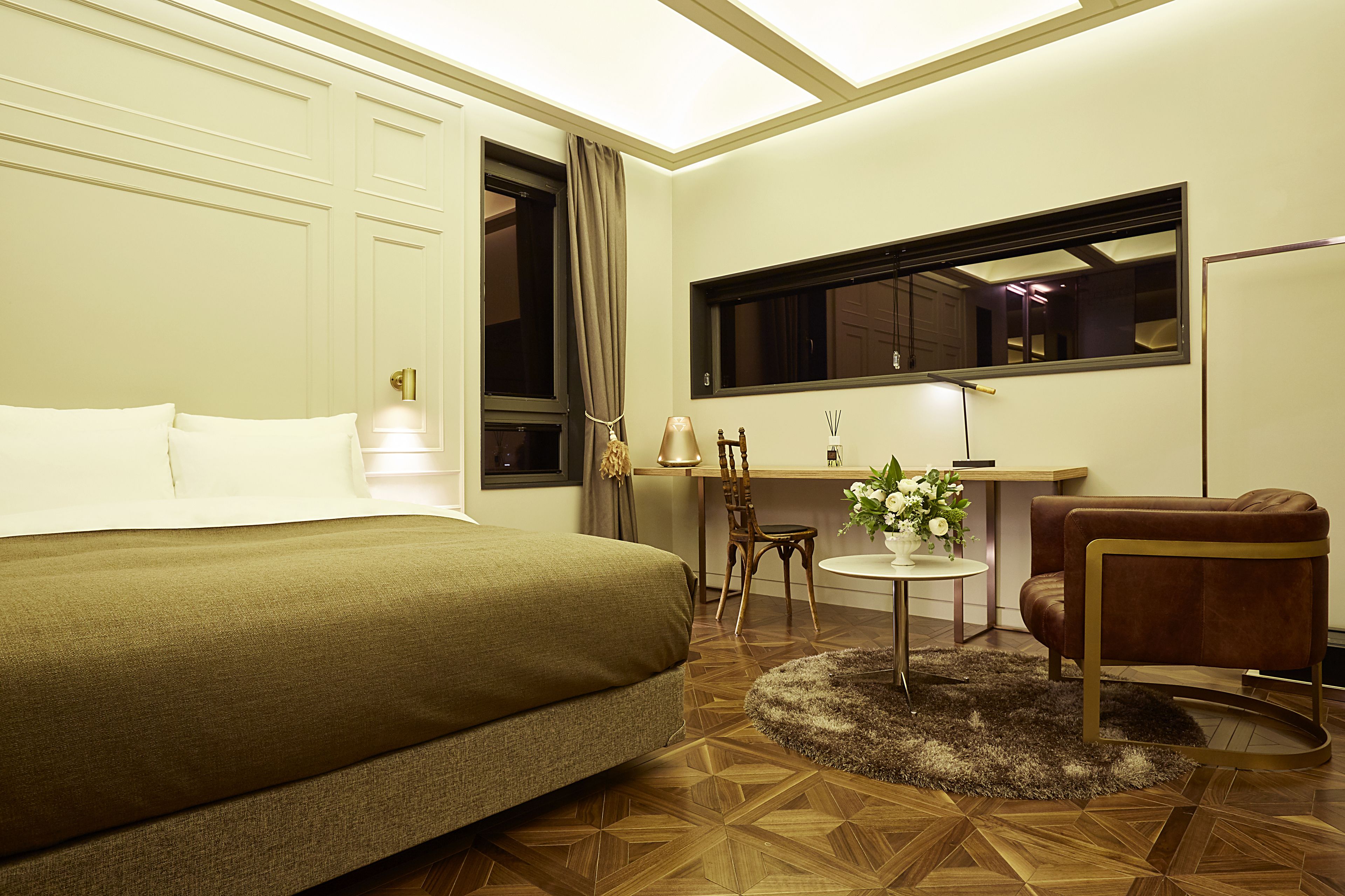 Una habitación de hotel con una cama, un escritorio, una silla y una ventana.