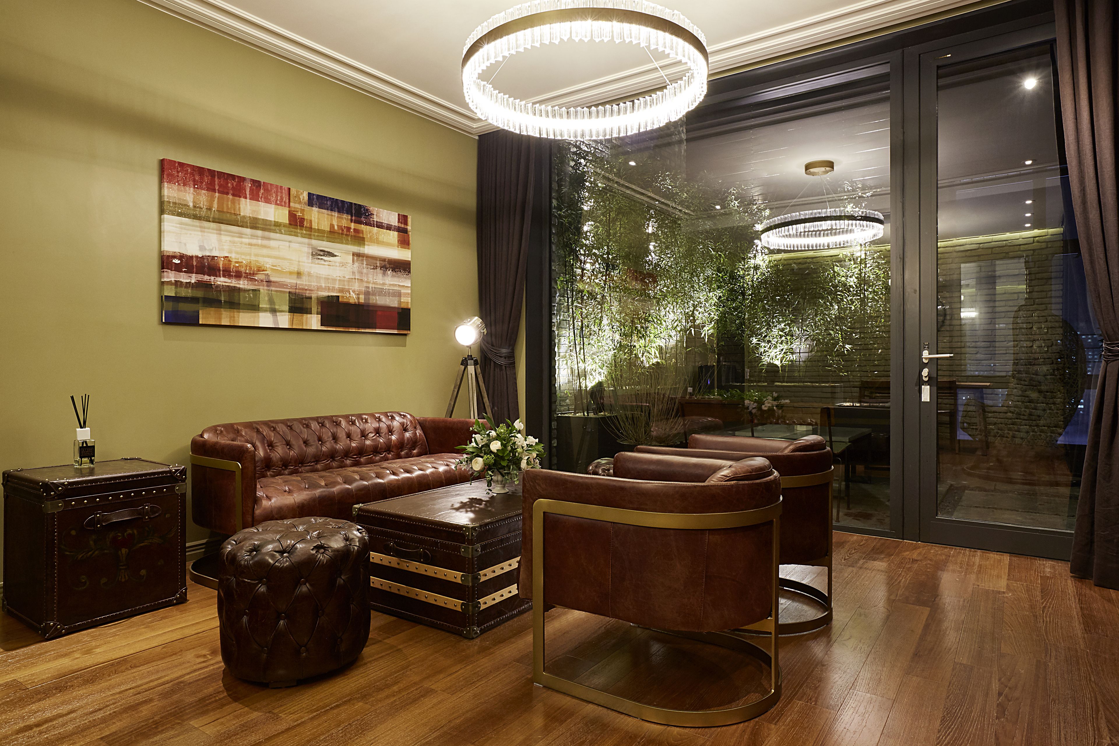 A modern living room with a leather sofa, a coffee table, and a chandelier.
