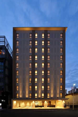 A modern hotel building with a flat facade, multiple windows, and a well-lit entrance area. - Hotel Nets Sapporo (Sapporo)