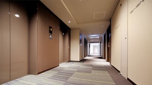 Un long couloir étroit, doté d’un revêtement de sol en moquette et de murs en bois.
