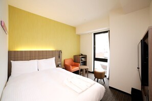 A hotel room with a large bed, a desk, a chair, and a small table. - Hotel Nets Sapporo (Sapporo)