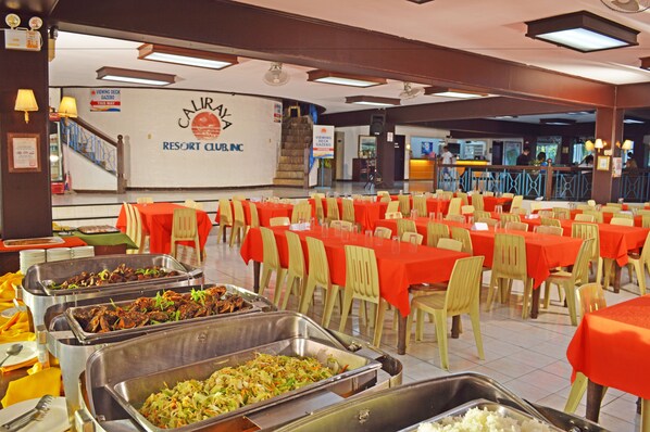 A buffet setup with multiple food stations and tables covered with red tablecloths. - Caliraya Resort Club (Lumban)