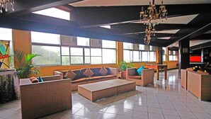 A spacious lobby with a high ceiling, large windows, and a chandelier. - Caliraya Resort Club (Lumban)