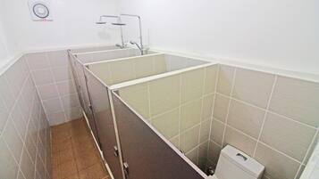A bathroom with a shower stall, a toilet, and a sink.
