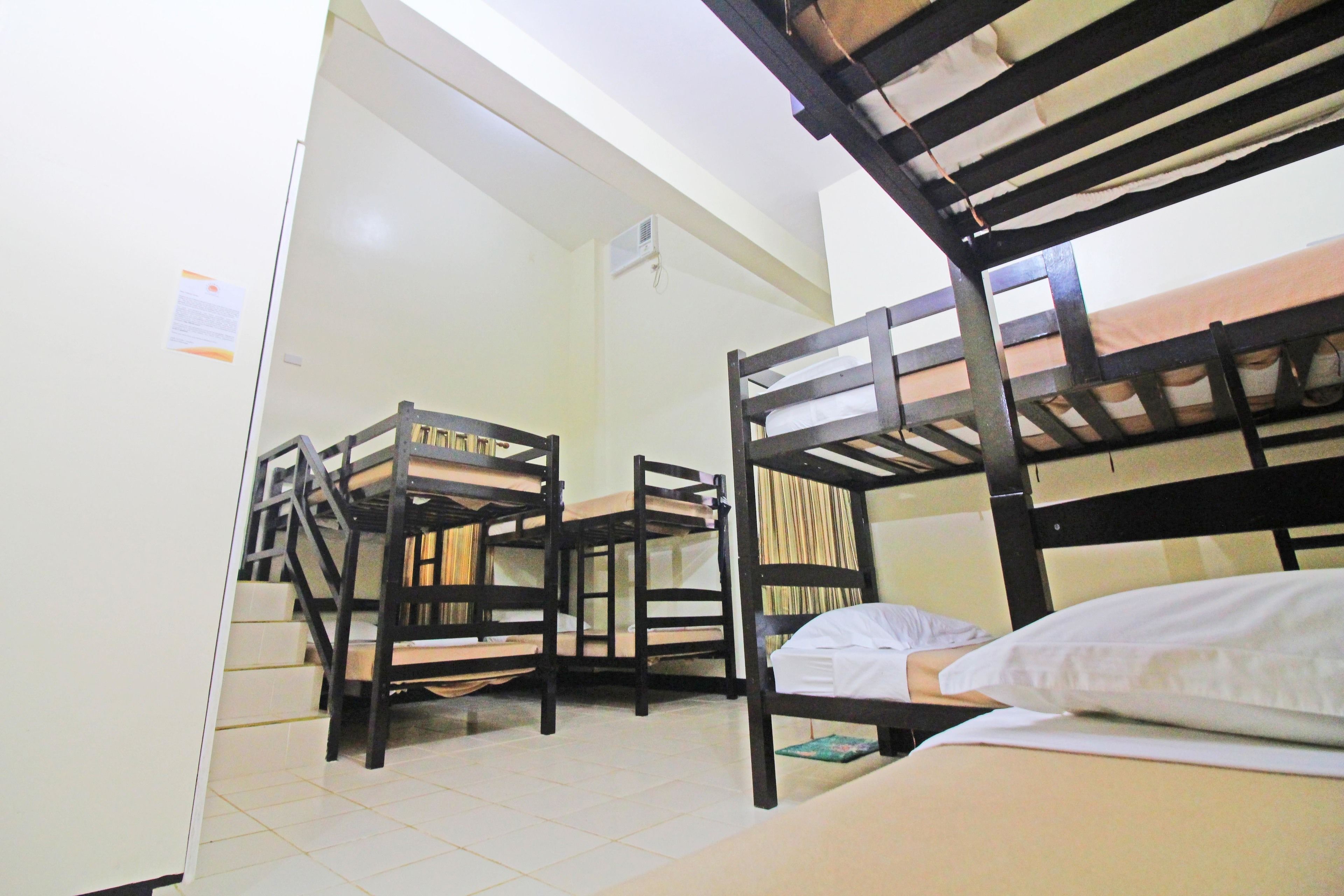 Habitación tipo dormitorio con literas, un escritorio y una silla.
