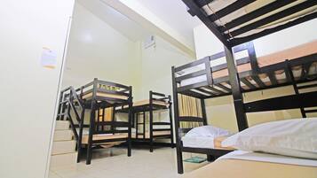 Habitación tipo dormitorio con literas, un escritorio y una silla.