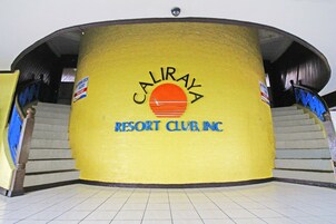 Un edificio con fachada amarilla y un letrero que dice "CALIRAYA RESORT CLUB, INC.".