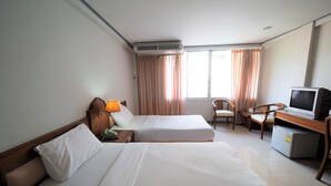 A hotel room with two beds, a desk with a computer, a chair, and a TV. - Pachara Hotel and Restaurant (Suphan Buri)