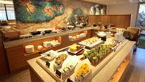 A buffet with various dishes and a large decorative wall.