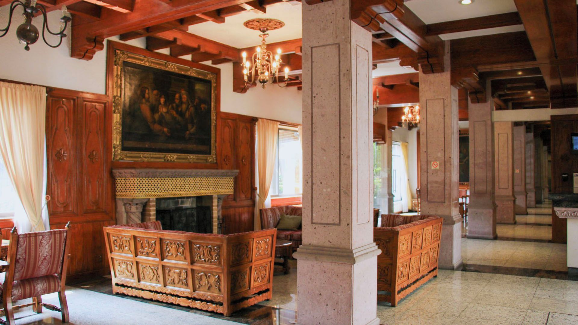 Un interior tradicional con chimenea, muebles de madera y un cuadro grande en la pared.