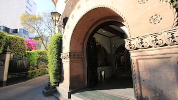 Una entrada con un arco, felpudo y un camino pavimentado que lleva a un edificio.