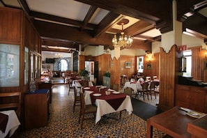 A restaurant with wooden interiors, tables set for dining, and a chandelier. - Hotel Maria Cristina (Mexico City)