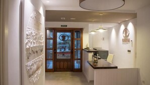 A reception area with a wooden door, a reception desk, and a wall-mounted artwork.