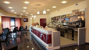 A modern bar area with a counter, seating, and a variety of bottles and glasses. - Hotel Torre del Duca (San Floro)