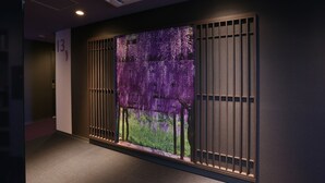 Ein Flur mit einer an der Wand montierten digitalen Anzeige mit einem violett-floralen Muster.