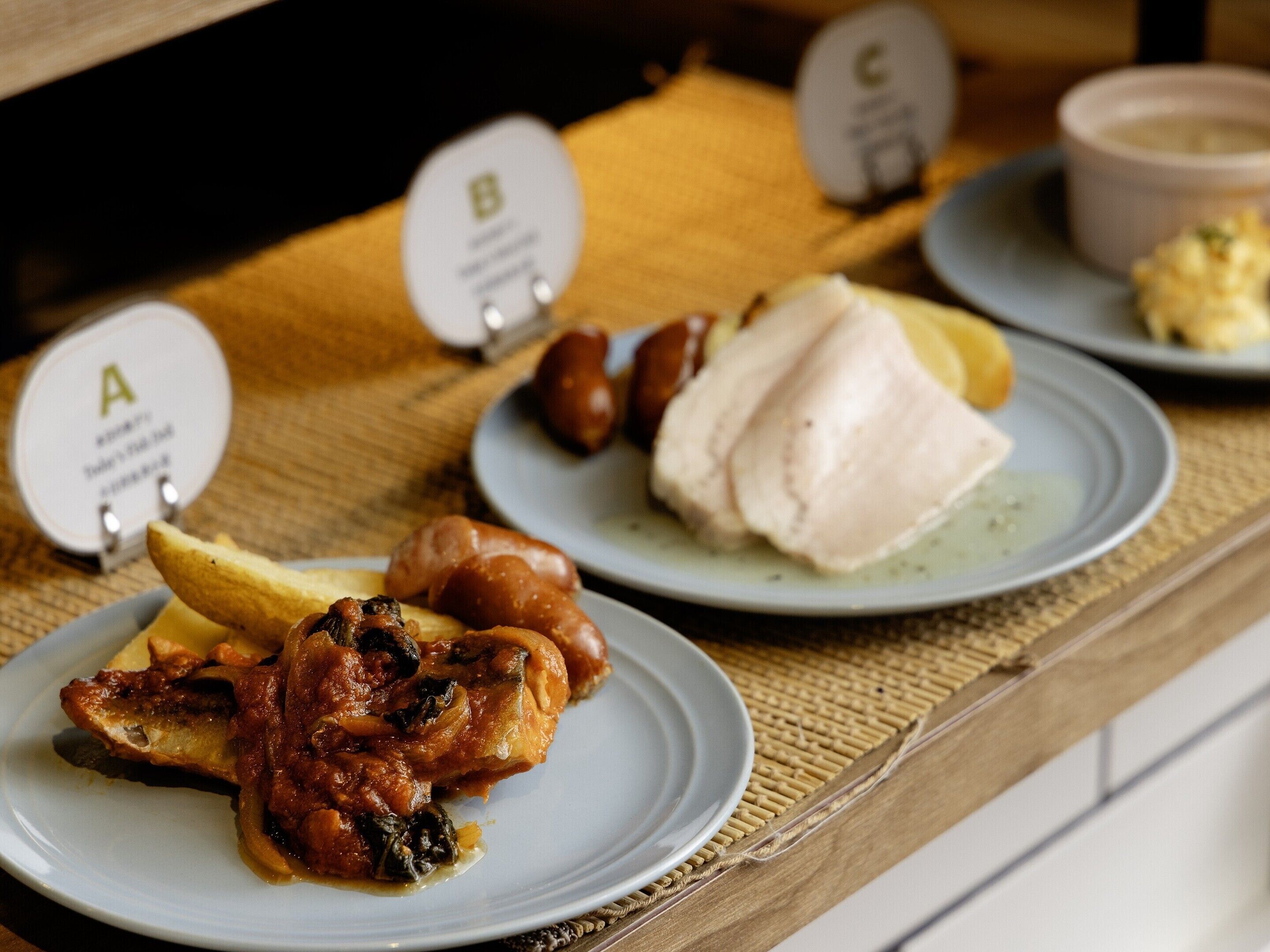 A buffet table with various dishes labeled A, B, and C.