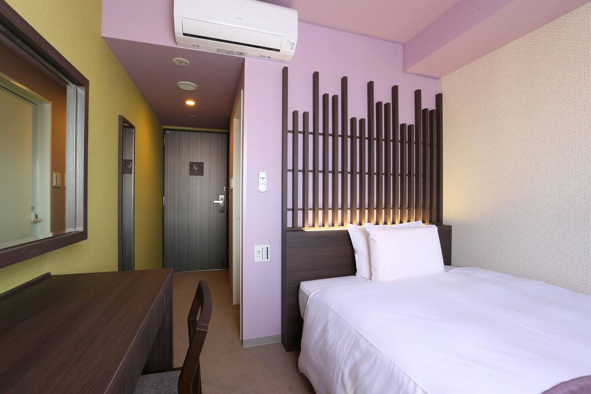 Ein Hotelzimmer mit einem Bett, einem Schreibtisch und einem Spiegel.